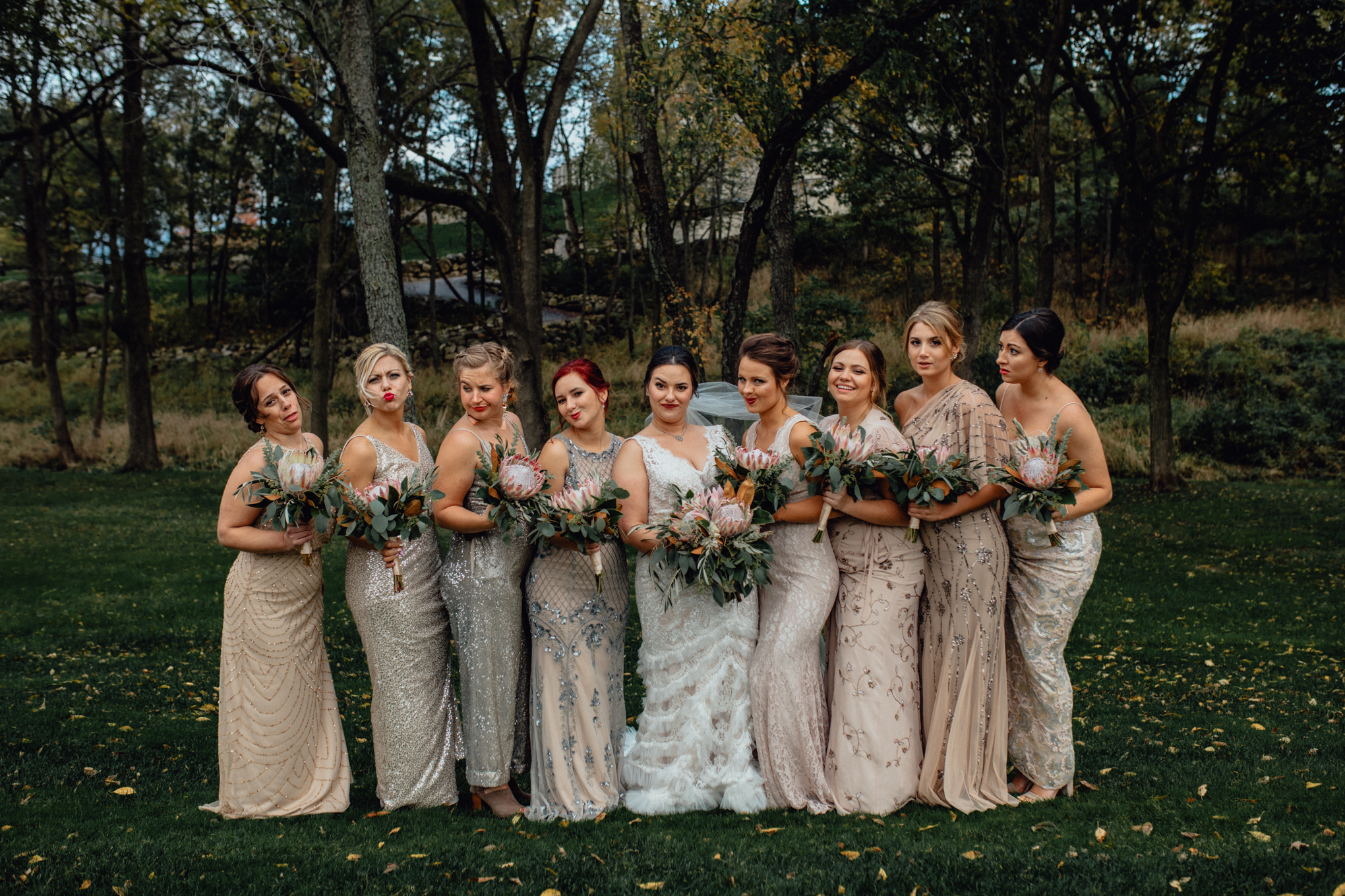  bridesmaids making kiss faces with bouquets in grass 