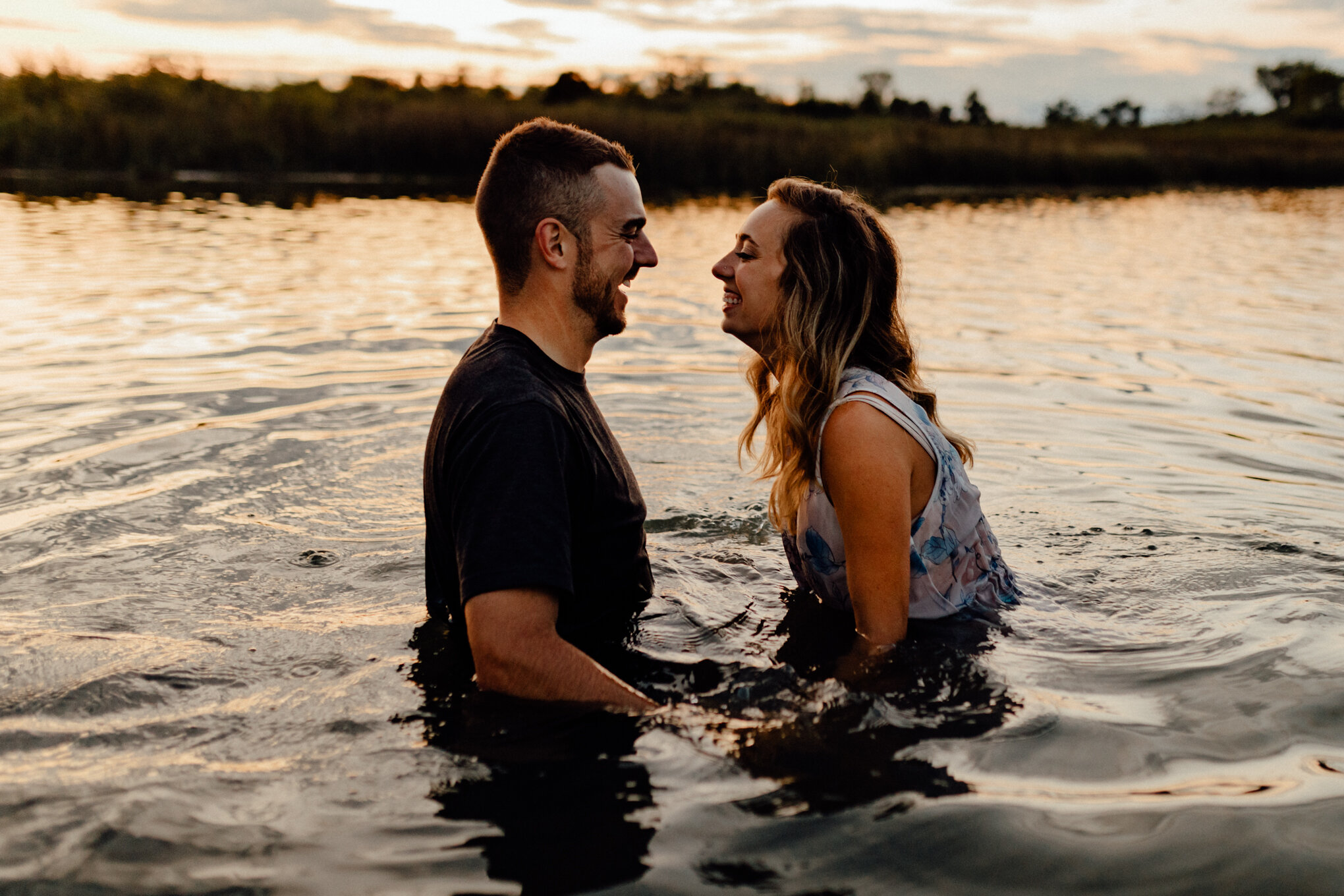  engaged couple in ottawa lake goofing around at sunset 