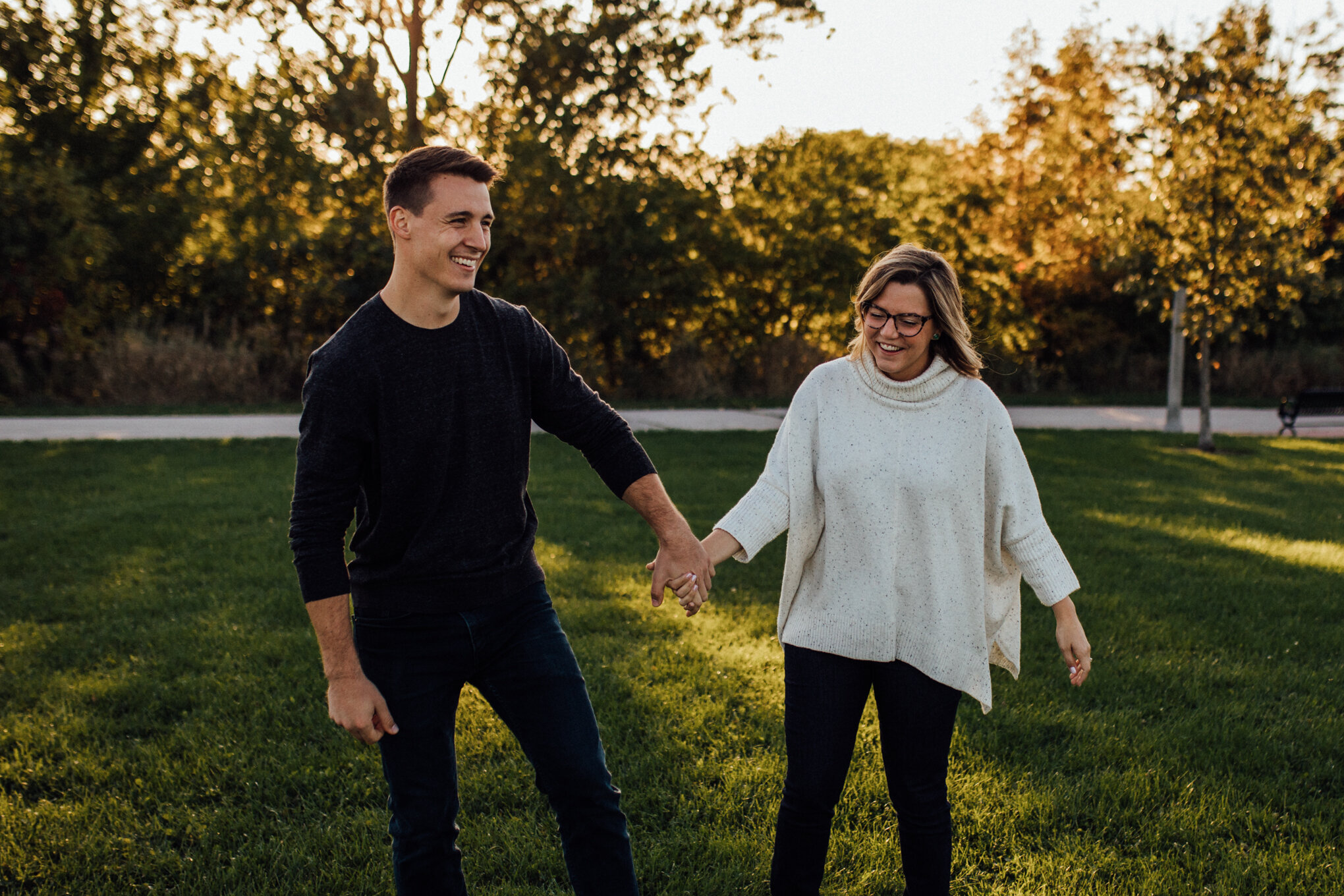  engaged couple spinning in field with sunshine in milwaukee engagement session 