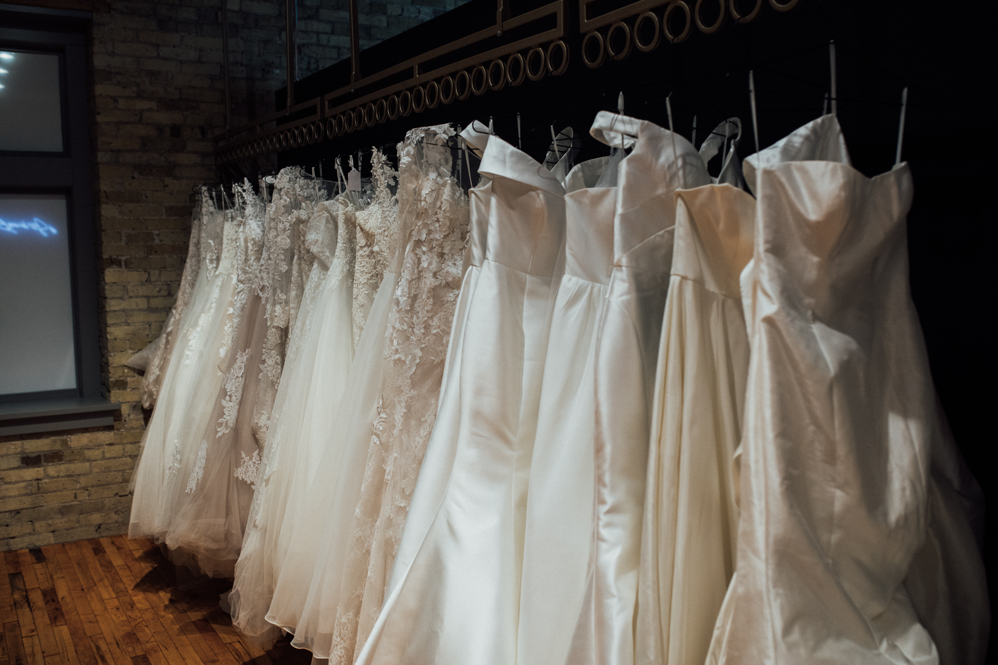 Dresses hanging on rack in spotlight at Strike Bridal Bar