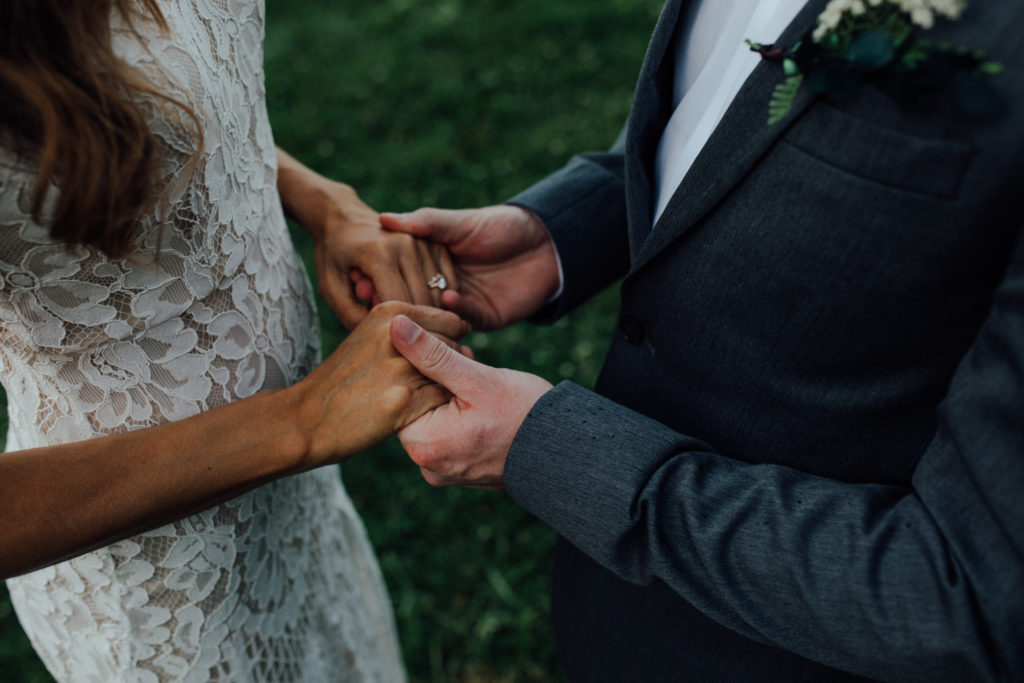 Close-up of bride and grooms hands holding
