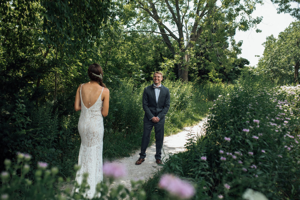 Groom sees bride for the first time on path in park during first look