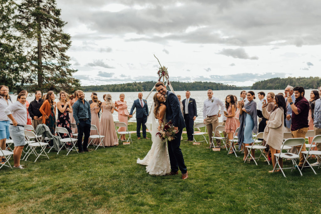 intimate boho wedding ceremony with bride and groom with huge smiles walking back down aisle after they've been married